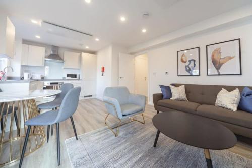 a living room with a couch and chairs and a kitchen at Modern 2 Bedroom Apartment in Ashford in Ashford