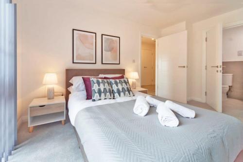 una camera da letto con un grande letto bianco con cuscini di Modern 2 Bedroom Apartment in Ashford ad Ashford