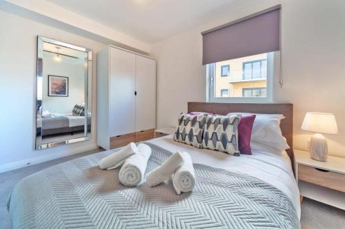 a bedroom with a large bed with towels on it at Modern 2 Bedroom Apartment in Ashford in Ashford