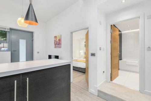a kitchen with a black and white counter and a bathroom at Modern 1 Bedroom Apartment in Central Woking in Woking