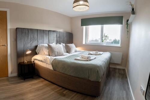 - une chambre avec un grand lit et une tête de lit en bois dans l'établissement Modern 1 Bedroom Apartment in Manchester, à Manchester