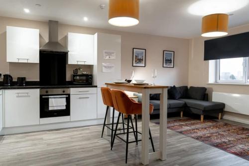 a kitchen and living room with a table and a couch at Modern 1 Bedroom Apartment in Manchester in Manchester