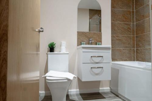 a bathroom with a toilet and a sink and a tub at Modern 1 Bedroom Apartment in Manchester in Manchester