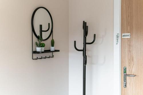 un miroir sur un mur avec une plante sur une étagère dans l'établissement Modern 1 Bedroom Apartment in Manchester, à Manchester