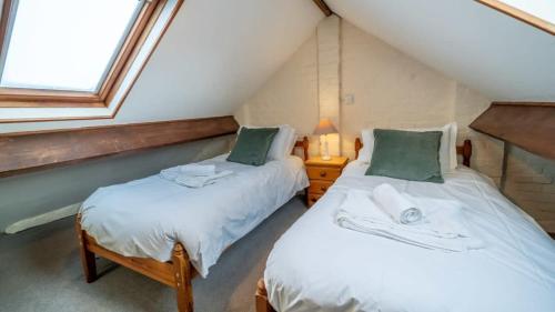 2 camas individuales en una habitación con ventana en Charming 3 Bedroom Holiday Cottage nr Bude, en Bude