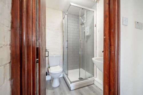 a bathroom with a shower and a toilet and a sink at Charming 3 Bedroom Holiday Cottage nr Bude in Bude
