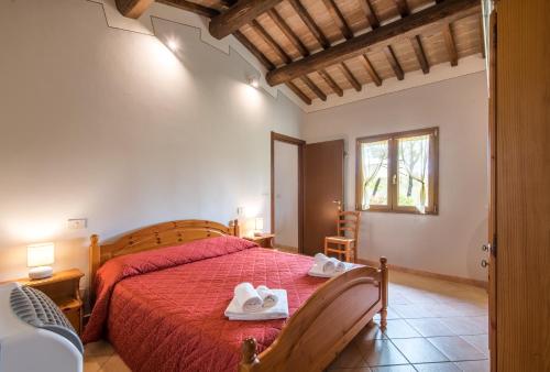 een slaapkamer met een rood bed en handdoeken erop bij Faetino - Gallo in San Marziale