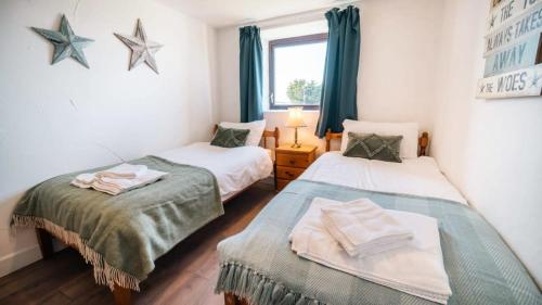 duas camas num quarto com estrelas na parede em Spacious 2 Bedroom Coastal Cottage nr Bude em Bude