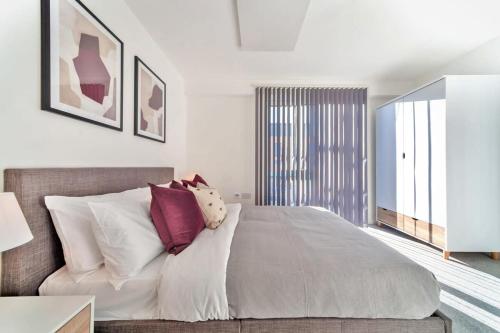 a bedroom with a large bed with white and purple pillows at Contemporary 2 Bedroom Apartment in Ashford in Ashford