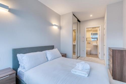 a bedroom with a white bed and a bathroom at Modern 2 Bedroom Apartment in Bracknell in Bracknell