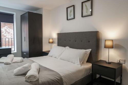 1 dormitorio con 1 cama grande con sábanas y almohadas blancas en Contemporary 1 Bed Apartment in Liverpool Centre, en Liverpool