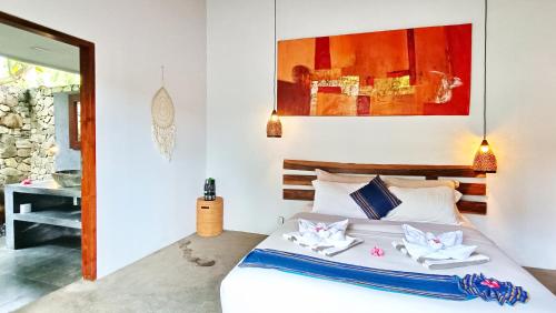 a bedroom with a bed with two towels on it at Kies Villas Lombok in Kuta Lombok