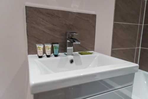 lavabo blanco en el baño con espejo en Contemporary 2 Bed Manchester Apartment - Sleeps 4 en Mánchester