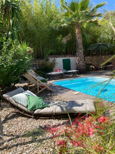 - une piscine avec une chaise longue à côté du complexe dans l'établissement Maison d hôtes LA VILLA MADELEINE, à Sanary-sur-Mer