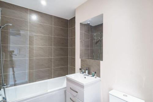 uma casa de banho com uma banheira, um lavatório e um chuveiro em Amazing 1 Bed Apartment in Manchester - Sleeps 2 em Manchester