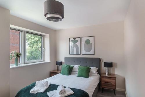 1 dormitorio con 1 cama con almohadas verdes y blancas en Amazing 1 Bed Apartment in Manchester - Sleeps 2 en Mánchester