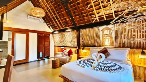 a bedroom with a bed with a bow on it at Kies Villas Lombok in Kuta Lombok