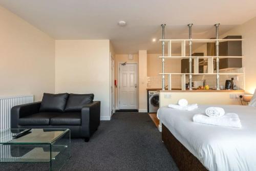 a hotel room with a bed and a couch at Modern & Bright Budget Studio in Central Doncaster in Doncaster