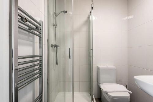 a bathroom with a shower and a toilet and a sink at Modern & Bright Budget Studio in Central Doncaster in Doncaster