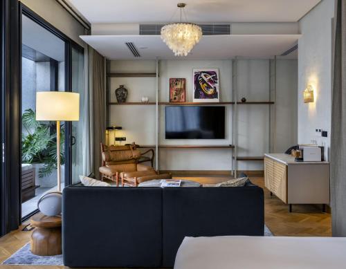 a living room with a couch and a television at Else Kuala Lumpur, a member of Design Hotels in Kuala Lumpur