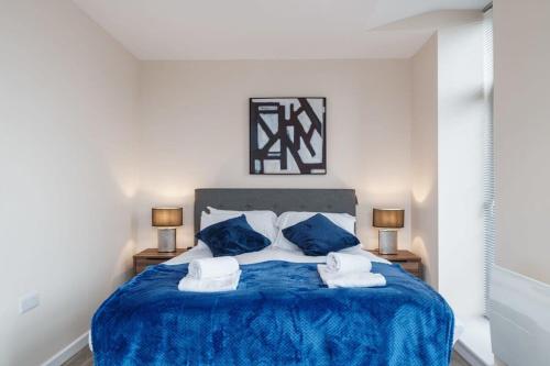 um quarto com uma cama azul e 2 almofadas em Bright 1 Bed Apartment Manchester - Sleeps 2 em Manchester