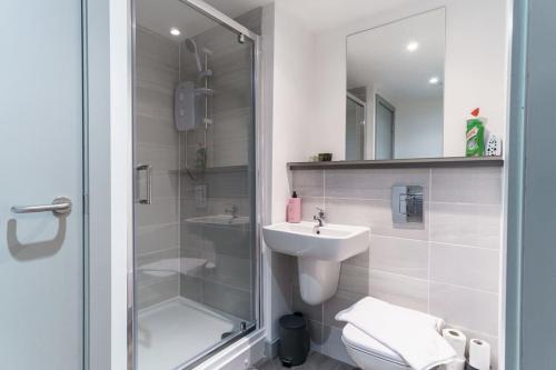 a bathroom with a shower and a sink and a toilet at Lovely 1 Bed Apartment in Central Liverpool in Liverpool