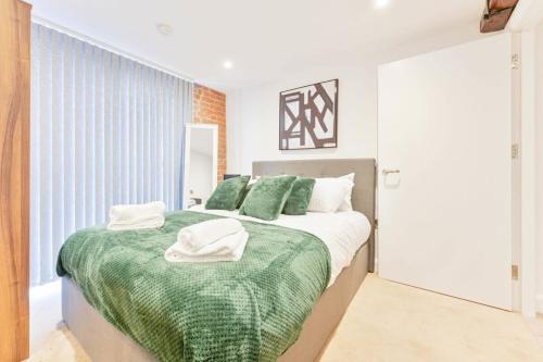 a bedroom with a large bed with green sheets and pillows at Cosy 1 Bedroom Apartment in Burton-on-Trent in Burton upon Trent
