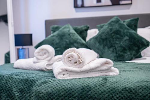 a pile of towels sitting on top of a bed at Modern 1 Bed Apartment in Burton-on-Trent in Burton upon Trent