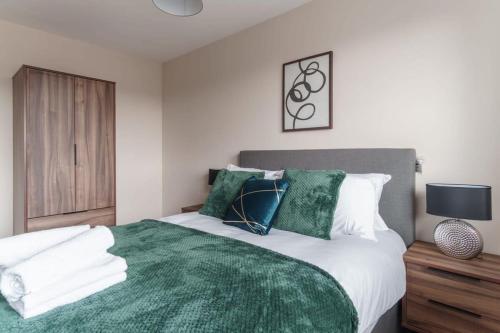 een slaapkamer met een groot bed en een groene deken bij Bright 2 Bed Apartment Manchester - Sleeps 4 in Manchester