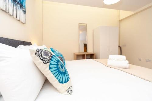 1 dormitorio con 1 cama blanca grande con almohadas en Characterful 2 Bedroom Apartment in Brixton, en Londres