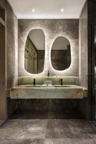 a bathroom with two mirrors and a sink at Else Kuala Lumpur, a member of Design Hotels in Kuala Lumpur