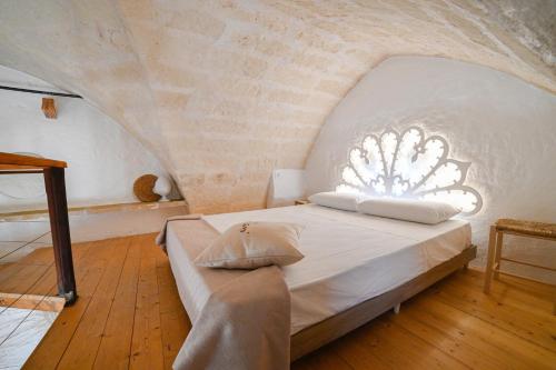 Un dormitorio con una cama en una pared de piedra. en M’ami, en San Cassiano