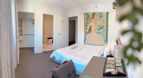 a bedroom with a bed and a table in it at Waikato Uni guest room with private bathroom in Hamilton