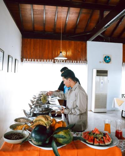 a chef preparing food in a kitchen with plates of food at Hokke Lumbini in Lumbini