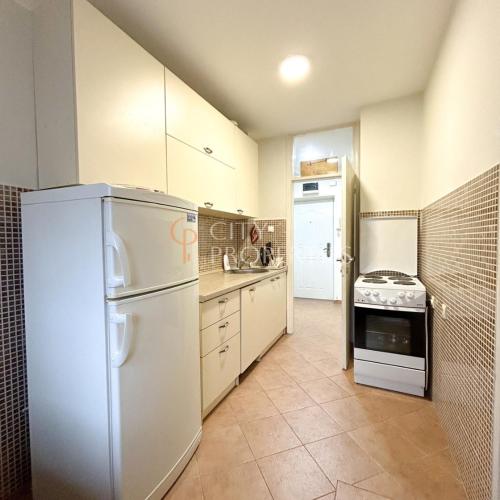 een keuken met een witte koelkast en een fornuis bij Charming and lovely apartment in Podgorica Center in Podgorica