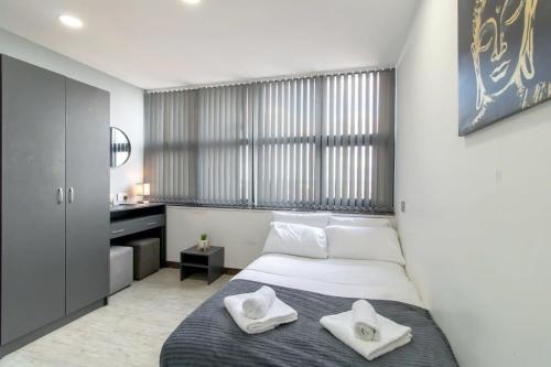 Budget Sunderland Studio with Lovely Views في سندرلاند: غرفة نوم عليها سرير وفوط بيضاء
