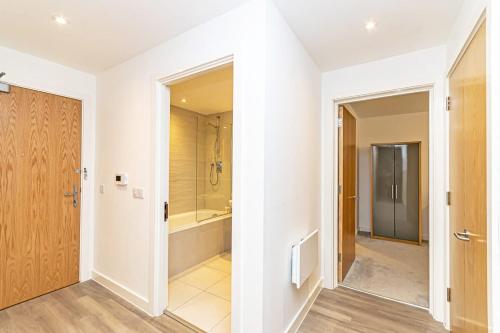 uma casa de banho com uma cabina de duche ao nível do chão e uma banheira em Contemporary 2 Bed Apartment in Central Manchester em Manchester