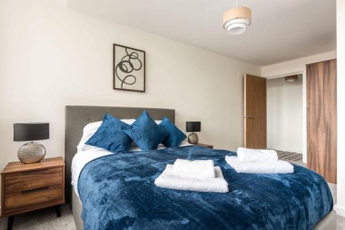 a bedroom with a large blue bed with blue pillows at Modern 1 Bed Apartment in Central Retford in Retford