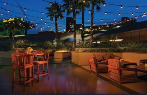 eine Terrasse mit einem Tisch, Stühlen und Lampen in der Unterkunft MGM Signature 30th Floor Penthouse w Balcony in Las Vegas