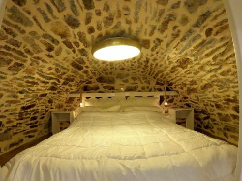 Sunday’s Holiday Houses في خيوس: غرفة نوم بسرير كبير في جدار حجري