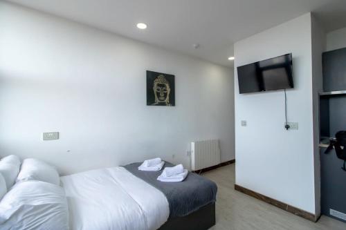 a hotel room with a bed and a flat screen tv at Lovely Central Sunderland Budget Studio in Sunderland