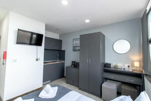 a room with a bed and a sink and a mirror at Lovely Central Sunderland Budget Studio in Sunderland