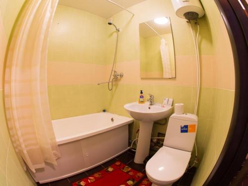a bathroom with a sink and a toilet and a bath tub at Павлова 64, 1 комнатная комфорт класса в центре от компании Home Hotel in Kostanay