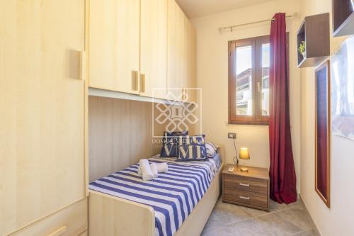 - une petite chambre avec un lit rayé bleu et blanc dans l'établissement La Belavi', à Castelsardo