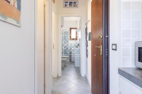- un couloir avec une salle de bains pourvue de toilettes et une télévision dans l'établissement La Belavi', à Castelsardo