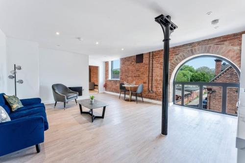 a living room with a blue couch and a brick wall at Stunning 1 Bed Apartment in Burton-on-Trent in Burton upon Trent
