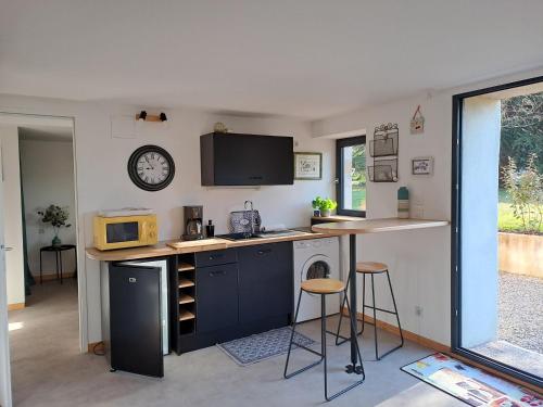 une petite cuisine avec un comptoir et un micro-ondes dans l'établissement Les Glycines, à Salles-la-Source