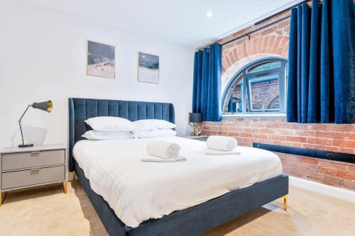 a bedroom with a large bed with a brick wall at Stunning 1 Bed Apartment in Burton-on-Trent in Burton upon Trent