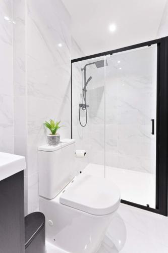 a white bathroom with a toilet and a shower at Stunning 1 Bed Apartment in Burton-on-Trent in Burton upon Trent