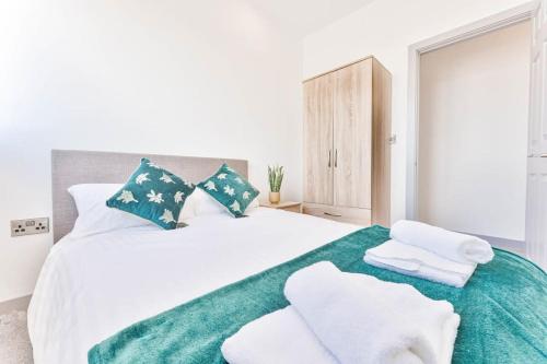 ein Schlafzimmer mit einem großen weißen Bett mit Handtüchern darauf in der Unterkunft Modern 2 Bedroom Apartment Central Wolverhampton in Wolverhampton